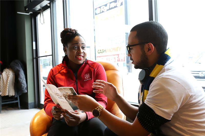 The Salvation Army staff member reviewing a brochure with a visitor.